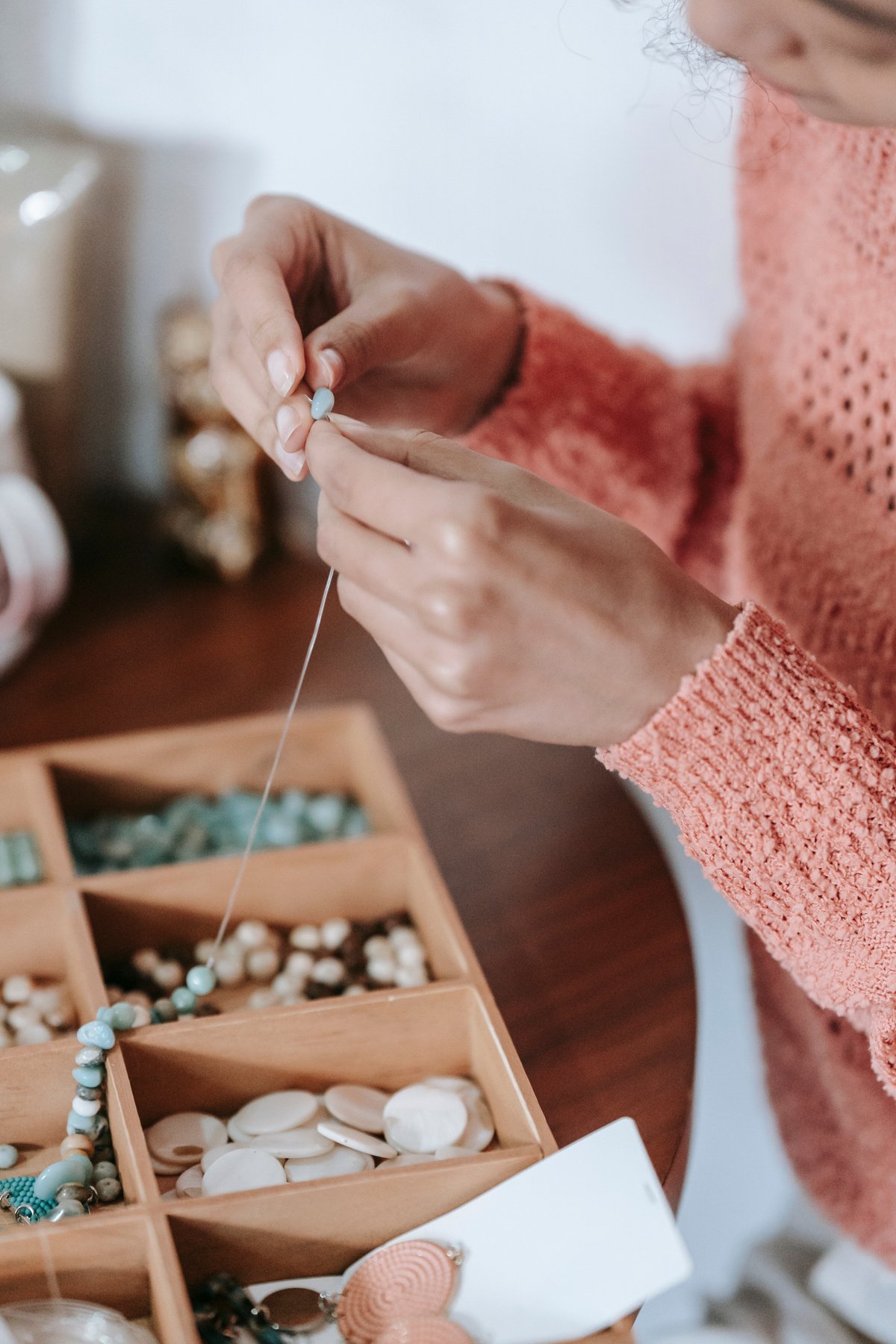 Crop unrecognizable craftswoman creating handmade accessory